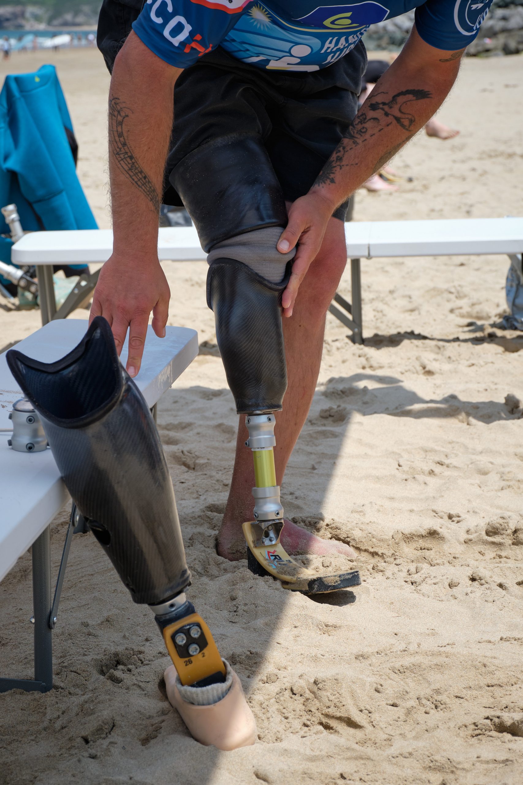 ACTIONS-Sport-2025 une personne amputée changeant de prothèses pour faire du surf avec un appareillage adapté